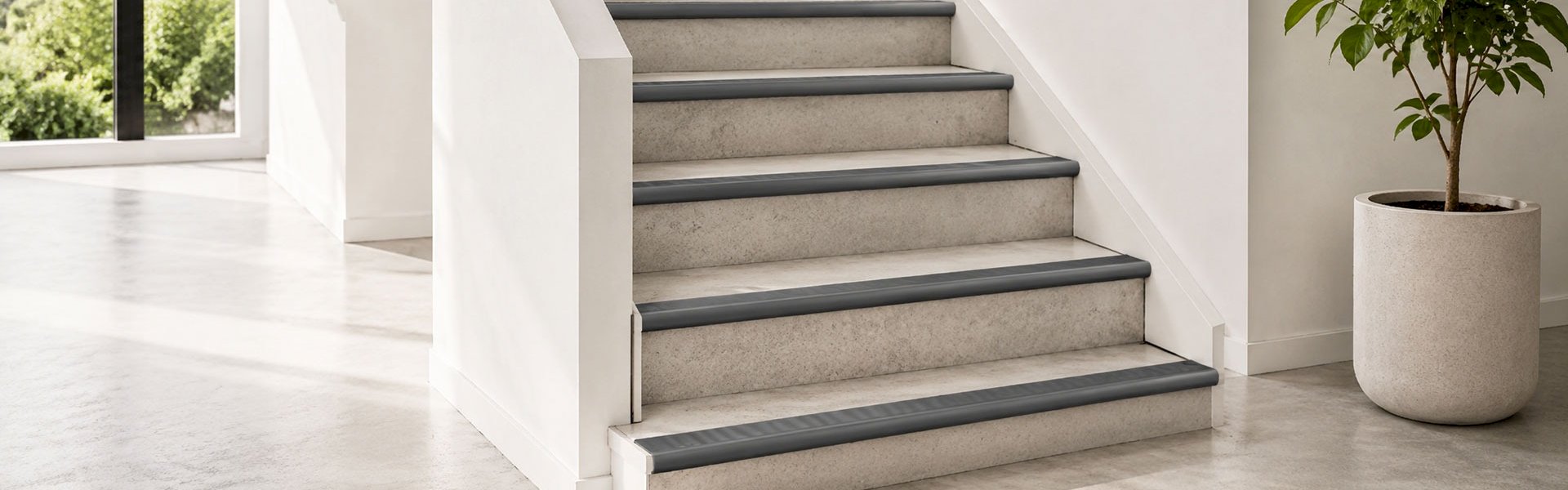 Modern concrete staircase with black rubber stair nosing.